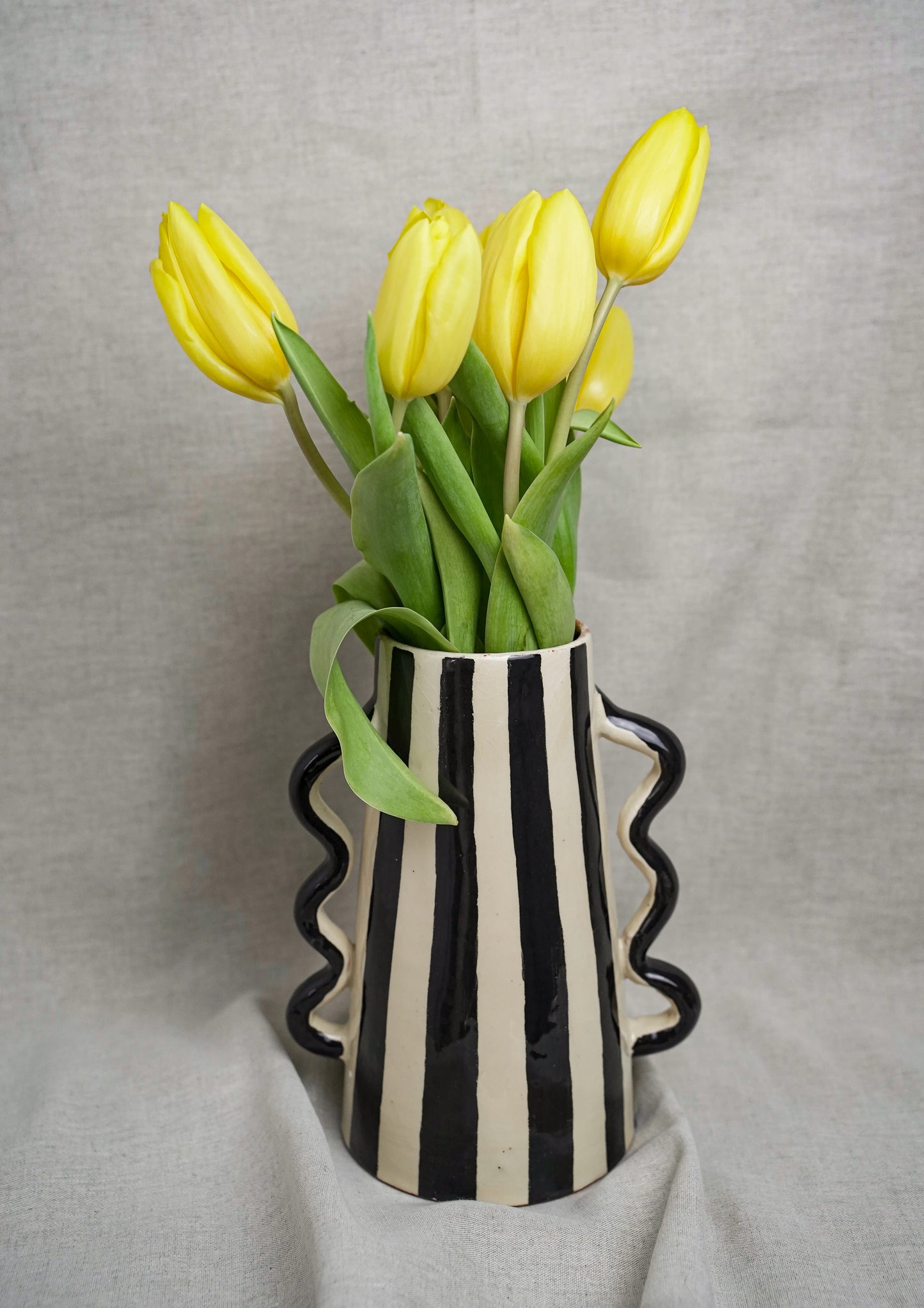 Vase en céramique rayé avec poignées ondulées